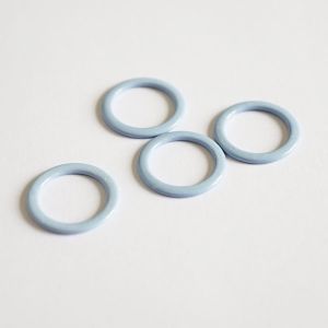 Vier glänzende, hellblaue Metall-BH-Ringe sind lose gestapelt. Das Nahaufnahme-Foto betont die hochwertige Verarbeitung und Stabilität dieser 9mm-Ringe.
