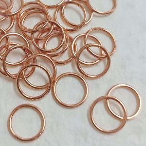Glänzende, rosegoldfarbige Metall-BH-Ringe sind lose gestapelt. Das Nahaufnahme-Foto betont die hochwertige Verarbeitung und Stabilität dieser 10mm-Ringe.