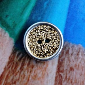 Strukturierter 18mm Kunststoffknopf in Gold mit Silberrand. Lichtbrechende Oberfläche für starken Glanz. Ideal für Kinderkleidung bei Spitzentraum.ch.