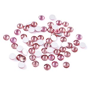 Nahaufnahme glänzender Pink Hotfix Glas-Strasssteine (SS30). Zeigt Details der Facetten und den schmelzenden Kleber für Textilien. Ideal für DIY.