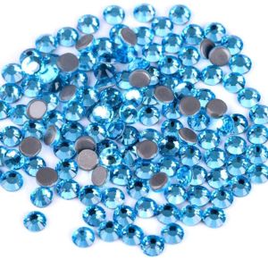 Nahaufnahme glänzender Aquamarine Hotfix Glas-Strasssteine (SS10). Zeigt Details der Facetten und den schmelzenden Kleber für Textilien. Ideal für DIY.
