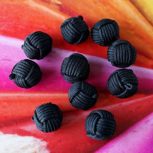 Zehn kugelförmige Knäuelknöpfe in der Farbe Schwarz. Die Oberfläche aus feiner Satinkordel imitiert die Wicklung eines Wollknäuels und verleiht eine tolle Haptik.