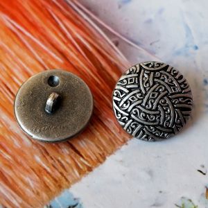 Vorder- und Rückseite eines 22mm Ösenknopfs im Kelten-Stil. Grauer Kunststoff mit dunkelgrauer Patina und stabiler Öse. Ideal für historische Kostüme und Cosplay.