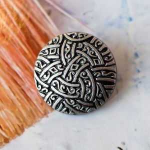 Runder 22mm Ösenknopf aus Kunststoff in Altsilber-Optik. Reliefartiges Muster mit verschlungenen Ornamenten im Kelten-Stil für Jacken und Mäntel.