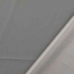 Reflektierender Stoff, der locker drapiert ist. Das Bild zeigt die dünne und leichte Qualität des Materials sowie die weisse Rückseite aus Polyester.