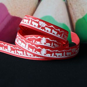 Nahaufnahme des Ripsbandes in rot. Das detailreiche, weisse Scherenschnitt-Motiv eines Alpaufzuges ist gut erkennbar.